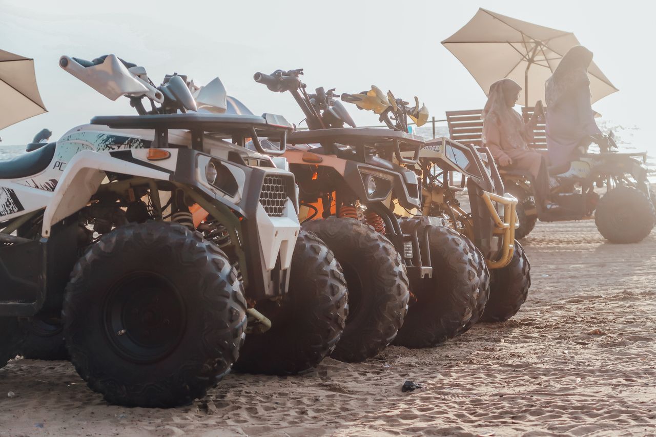 ATVs lined up in the desert with riders enjoying an offroad adventure under umbrellas.