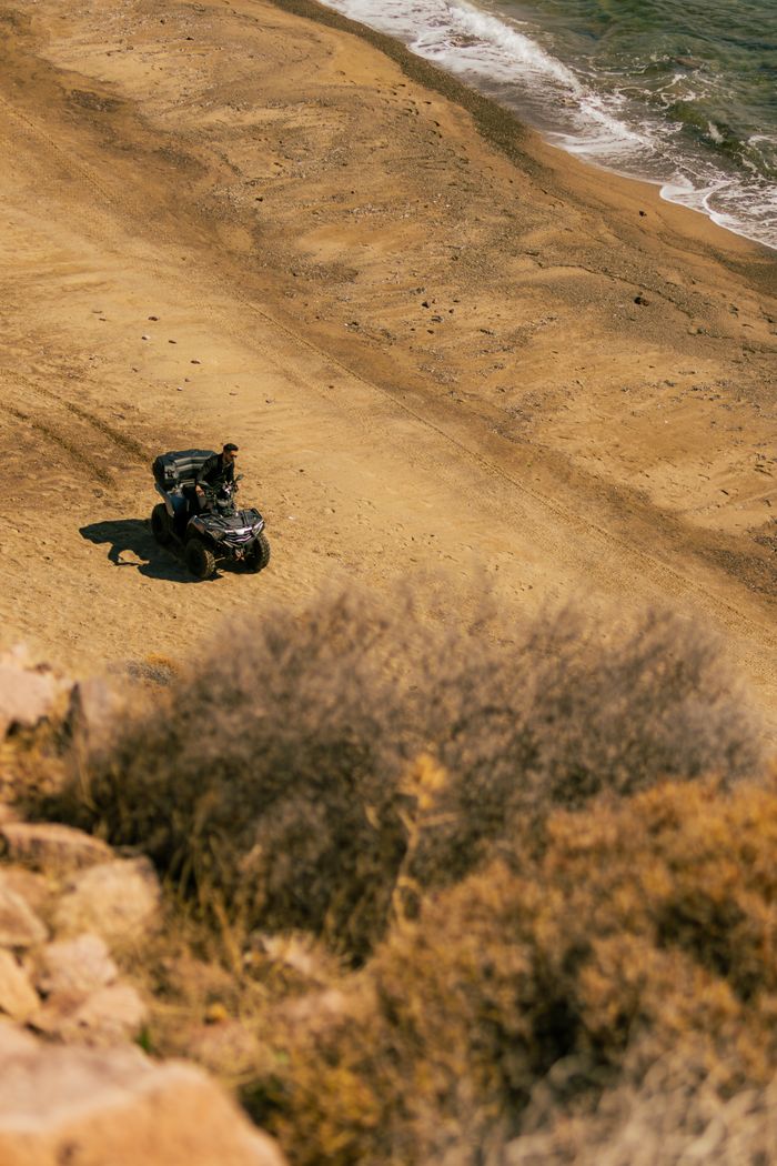 gallery-5 A lone ATV travels across an isolated beach, capturing a sense of adventure.
